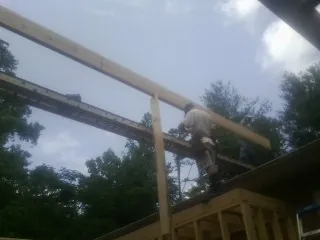 Carpenter setting a ridge beam over a new addition frame — Ice Dam Removal by Roofing Brothers in Hammondsport