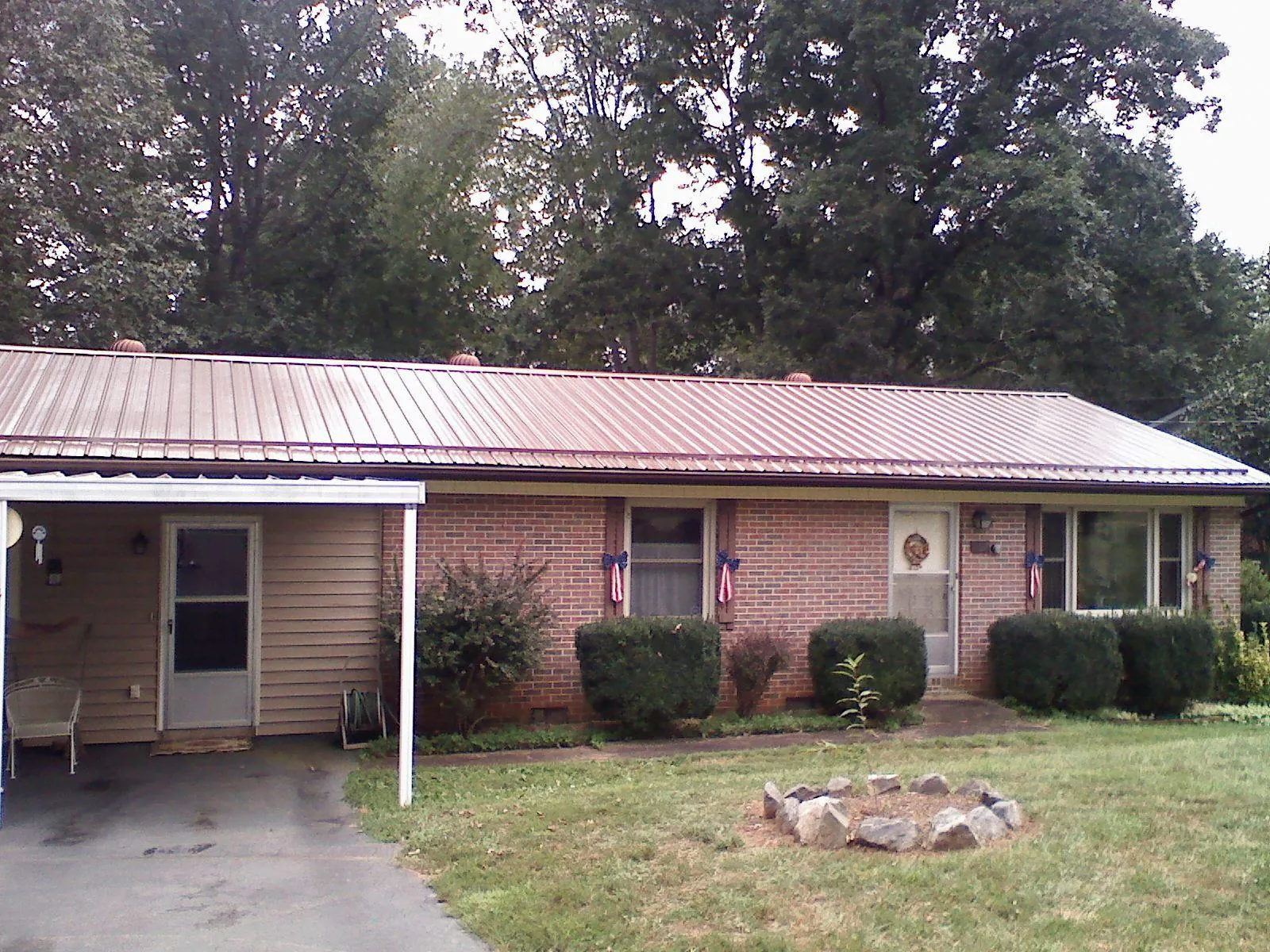 Bronze metal roof and carport on a brick ranch home — Roof Repair work by our crew in Hammondsport